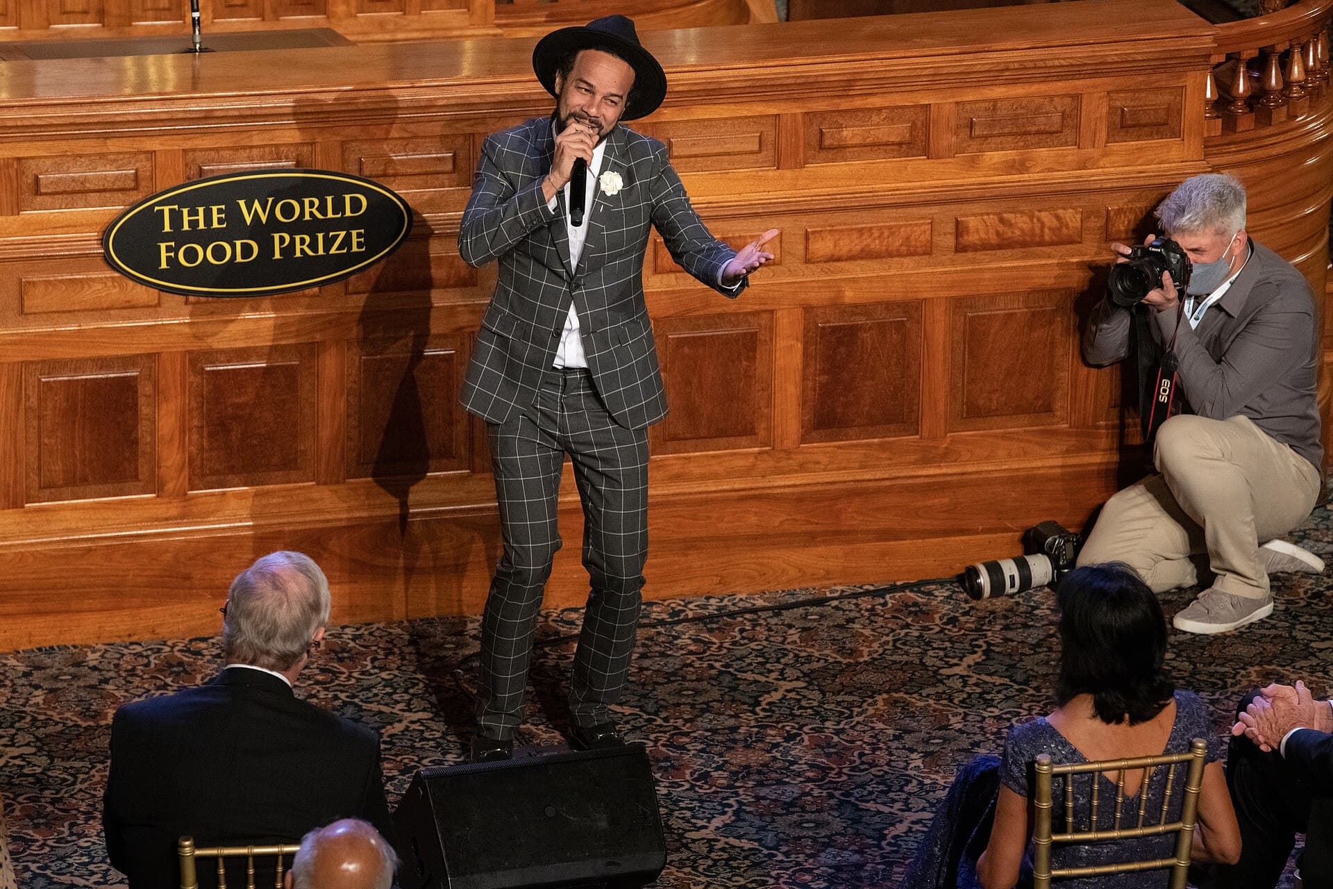 Kees Dieffenthaller, lead singer of Kes, in a checked suit and hat singing into a microphone at the World Food Prize Laureate Award Ceremony in Des Moines, Iowa, in October 2021